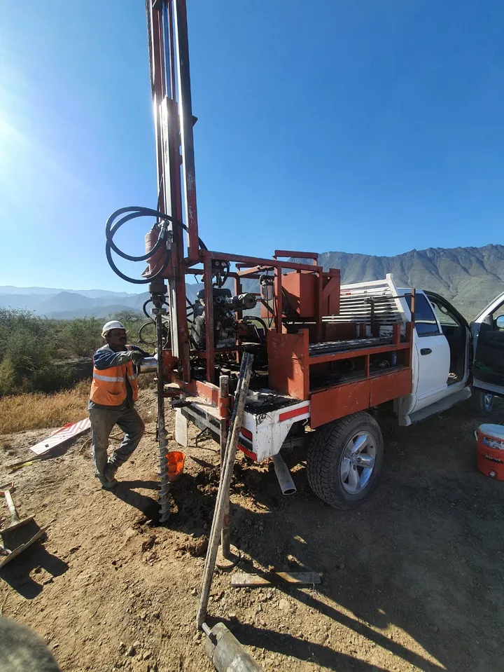 Perforadora de sondeo montada en camioneta haciendo exploración del subsuelo en campo