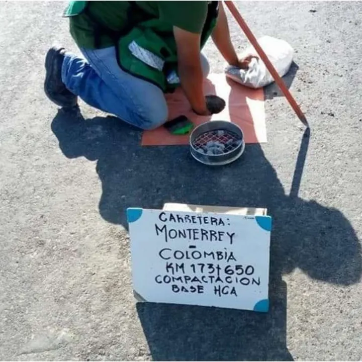 Técnico de Layen haciendo una prueba de compactación de base hidráulica junto a un letrero de la carretera Monterrey–Colombia km 17+650